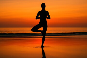 Fototapeta premium Woman silhouette in yoga tree pose on beach at orange sunset