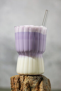 Ube latte in glass on the stone. Healthy vegan drink. Viral trendy asian beverage