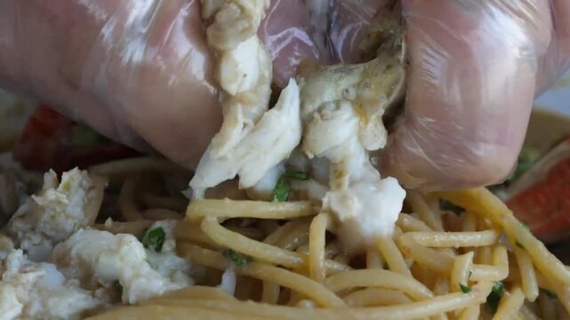 A close-up shot of a chef's hands wearing clear plastic gloves, expertly pulling and shaping raw pizza dough. The footage emphasizes the elastic texture of the dough and professional hygiene standards