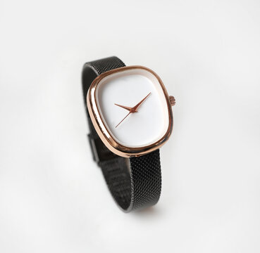 Elegant Rose Gold Oval Wristwatch with Black Mesh Strap isolated on White Background