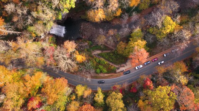 Scenic highway near beautiful waterfall in North Carolina. Aerial view of Looking Glass Falls near Brevard. Forest staircase, viewing platform and nearby road create picturesque landscape.