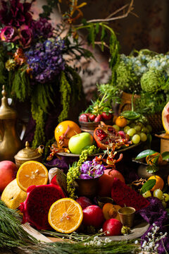Colorful gourmet fruit still life featuring fresh tropical and citrus fruits arranged with decorative tableware