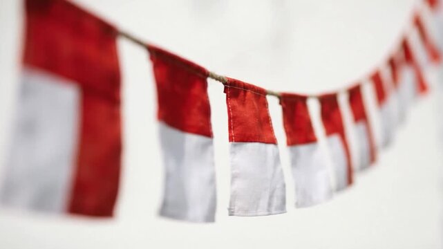 Close-up of a string of Indonesian flags fluttering gently in the wind, celebrating national pride and independence.