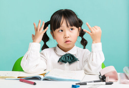 Asian schoolgirl counting on fingers while studying at desk, thinking and math learning concept, education and problem solving