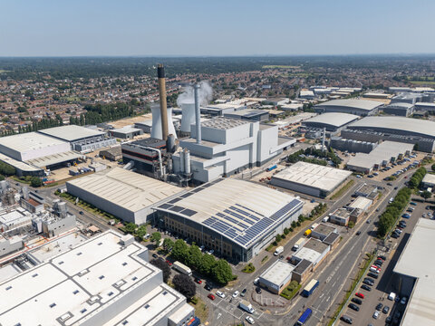 Slough, United Kingdom - 24 June 2026: Aerial view of Slough Trading Estate featuring industrial buildings, warehouses with solar panels, and a prominent power station with cooling towers.