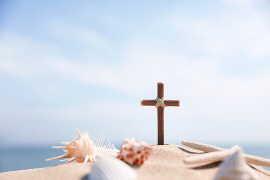 A cross and a conch shell on the seaside beach, a summer retreat and summer Bible school, and a cool summer camp background.
