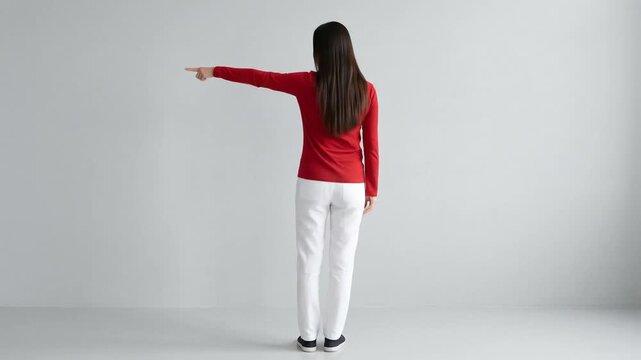Woman in red shirt and white pants pointing in different directions in a studio setting