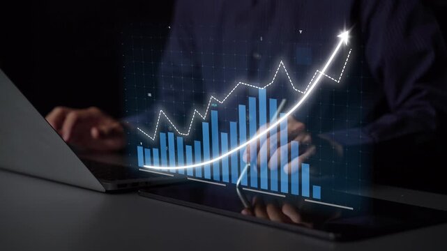 A businessman analyzes data trends using a laptop and tablet, showcasing a digital graph that emphasizes growth and innovation in a modern office environment. Copula
