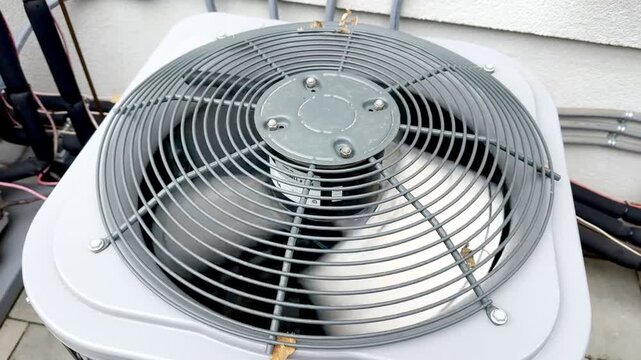 Residential Outdoor HVAC Condenser Units.Modern residential air conditioning condenser units installed beside a house with paved walkway and visible utility connections.