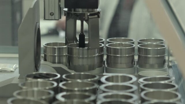 Automated equipment handling metal test samples in an engineering laboratory. Ideal for industrial research, quality control, materials testing and technology concepts.