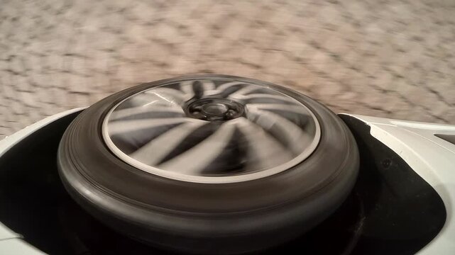 Close-up of a car wheel rolling over a cobblestone street, capturing motion, urban driving and road texture from a unique perspective.