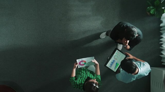 Top down view of businessman thinking about marketing plan or making decision to invest in startup project while smart professional business team sharing idea by using tablet at meeting. Convocation.