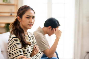 Fototapeta premium Relationship problems family crisis asian couple divorce marriage sad worried man husband thinking solution contemplating offended woman wife sitting in living room.