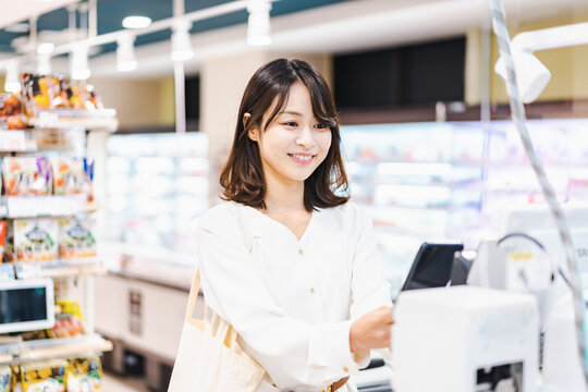 スマホ決済で支払う若い女性