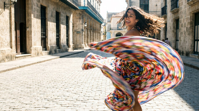 Joyful woman twirling in colorful dress on old town street