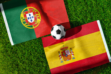 Fototapeta premium Portugal vs Spain, Round of 16, national flags before international football match, football on green grass with stadium in the background