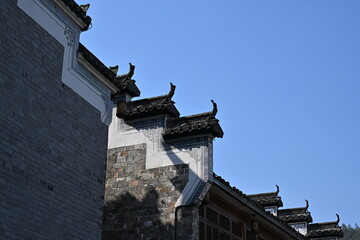 Fototapeta premium Weathered late-Qing dynasty dwellings stand in silent elegance, their grey brick facades and curved eaves whispering tales of a fading era.