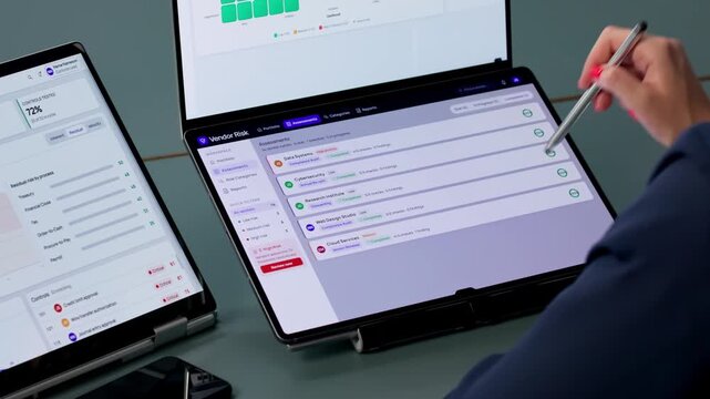 Risk Manager Analyzes Compliance Data On Dual-screen Laptop