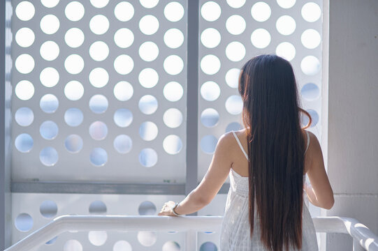 Woman with Long Hair Looking Out Window with Circular Designs
