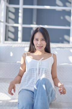 Young woman relaxing on stairs with soft sunlight casting shadows