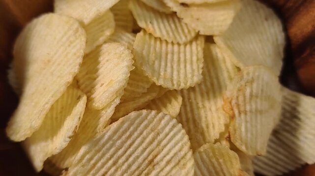 A pile of wavy, ridged potato chips up close
