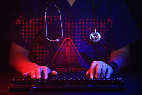Anxious doctor typing on computer keyboard representing healthcare IT security data breach threat with stethoscope visible