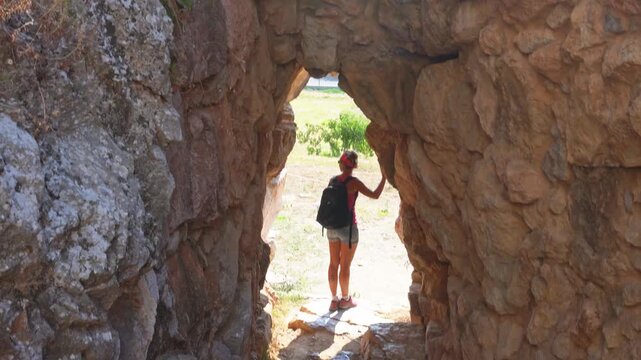 Woman exploring ancient stone ruins in Tiryns, Greece