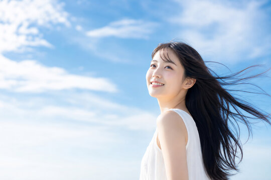 青空を見上げる笑顔の美しい日本人女性 Generative AI