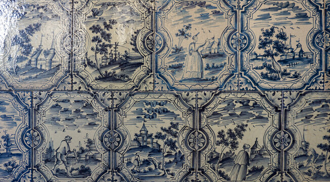 Antique Delftware ceramic tiles with blue and white hand painted scenes of rural life, figures and architecture. Dutch heritage, storytelling tradition, craftsmanship and ornamental interior design