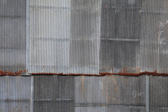 Artistic of old and rusty zinc sheet wall. Vintage style metal sheet roof texture. Pattern of old metal sheet. Rusting metal or siding. Corrosion of galvanized. Background and texture in retro concept