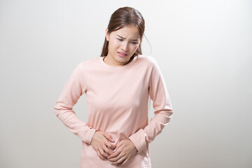 Obraz premium Flatulence asian young woman intolerance hand in stomach ache, suffer from food poisoning, abdominal pain and colon problem, gastritis or diarrhoea when at home. Patient belly, abdomen or inflammation