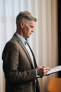 Senior businessman going through paperwork and documents at office
