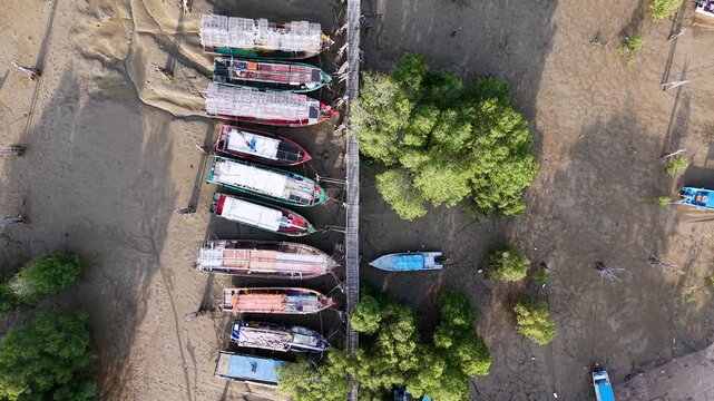Aerial view of boats docked on muddy riverbank