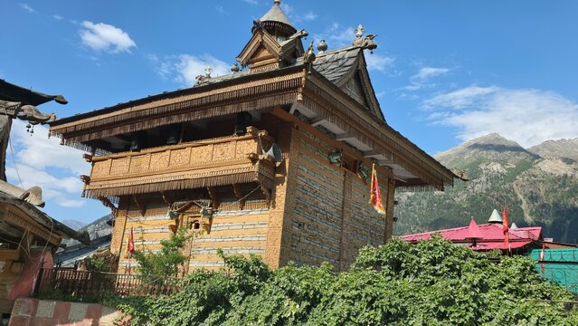 Side view highlights detailed wooden carvings and stone walls of historic Himalayan temple.