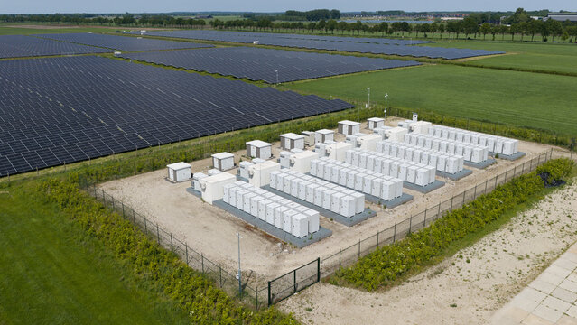 Steenbergen, North Brabant, Netherlands - 23 May 2026: Aerial view of a large solar farm featuring rows of photovoltaic panels and a battery energy storage system enclosure.