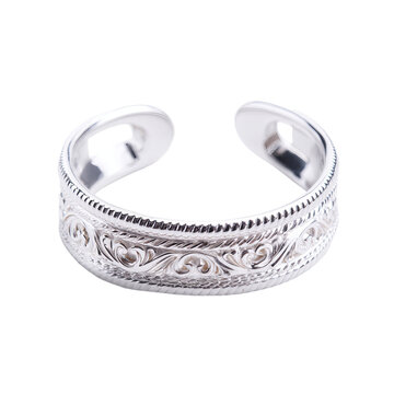 Close-up of a silver open toe ring, intricately carved with floral and swirling patterns, set against a black backdrop