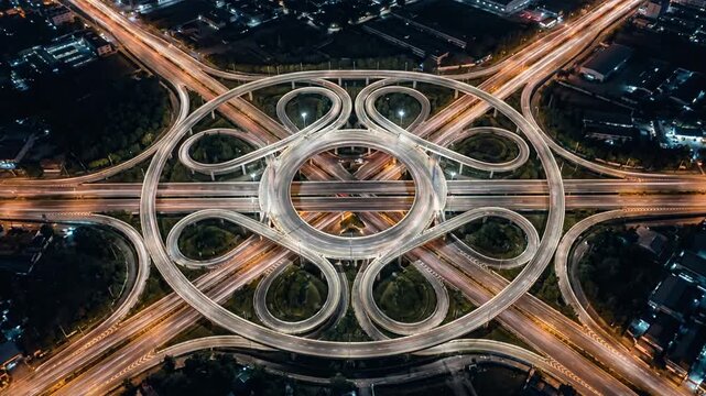 Top down night view of intricate cloverleaf interchange.
