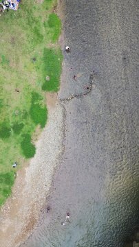 Aerial View of People by a Riverbank