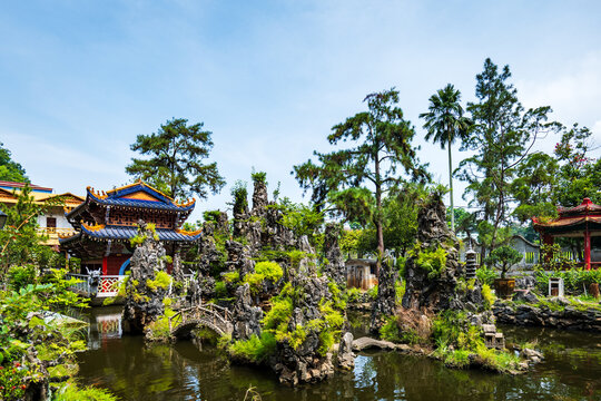 Ornate Chinese pavilion with dragon sculptures over garden pond at Sam Poh Tong cave temple, Ipoh, Malaysia