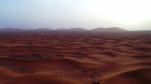 Drone aerial view of the spectacular Erg Chebbi sand dunes in Merzouga, showcasing Morocco's iconic Sahara Desert and its endless golden dune landscapes.