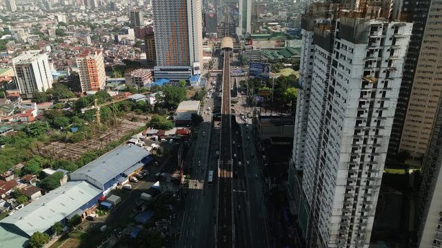 Traffic Along The EDSA Highway And MRT Track Passing High-Rise Buildings In Cubao, Metro Manila, Philippines. aerial shot