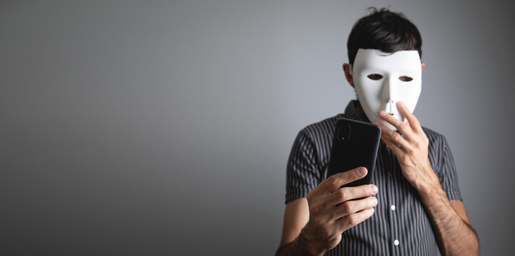 Man with a white mask using smartphone.