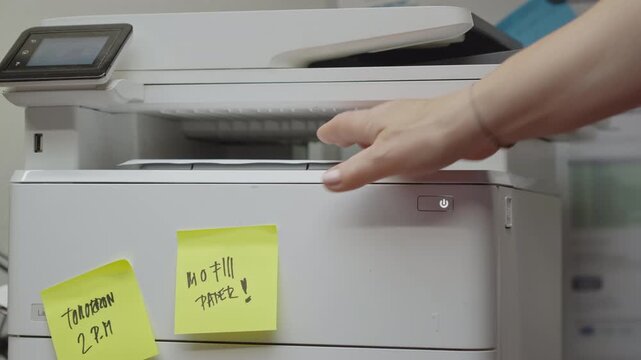 Printed documents are collected from an office printer marked with reminder notes, illustrating organized workflows, productivity, administration, and everyday business operations.