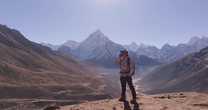 Thugla Pass, Everest Region, Nepal, drone orbits around a male hiker standing on a ridge looking out at Ama Dablam and the Khumbu peaks along the Everest Base Camp trekking route.