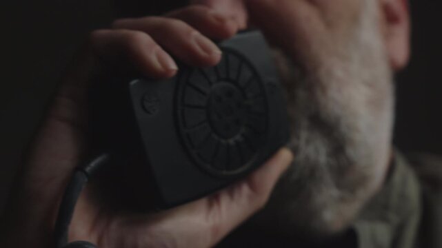 Tight close-up of an undercover operative speaking into a radio during a surveillance assignment. Captures tension, secrecy, intelligence gathering, and investigative operations.