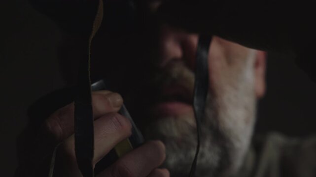 Extreme close-up of a surveillance operative using binoculars and a two-way radio during a covert observation. Ideal for espionage, stakeout, intelligence, security, and thriller productions.