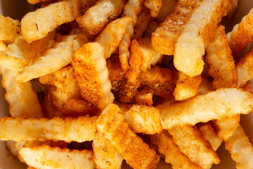 A top down view of a pile of cajun crinkle cut fries, as a background. © DAVID
