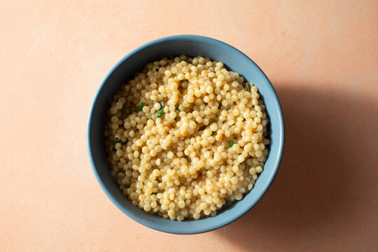 A top down view of a pearled couscous entree, in a bowl.