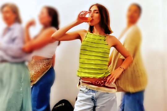 A beautiful young woman drinking.