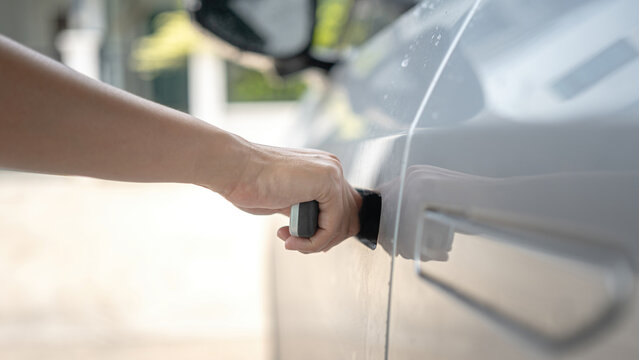 Action of people hand is pulling on flush door handle to open car's door.